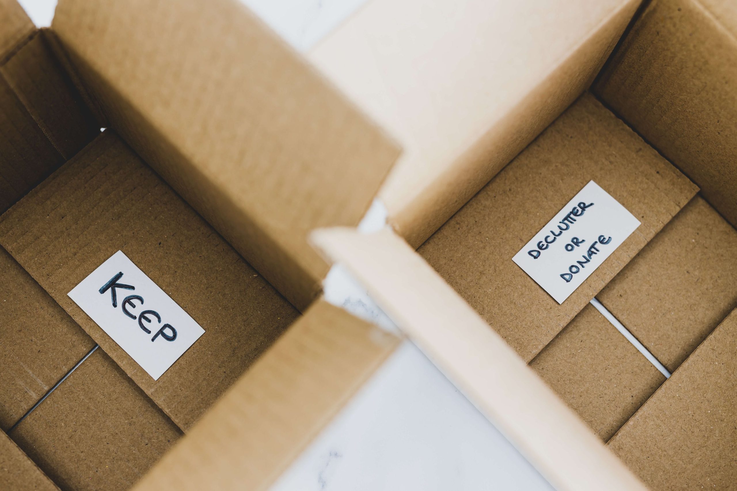 Two open cardboard boxes labeled "KEEP" and "DECLUTTER OR DONATE" offer tips for easier organization or downsizing tasks.