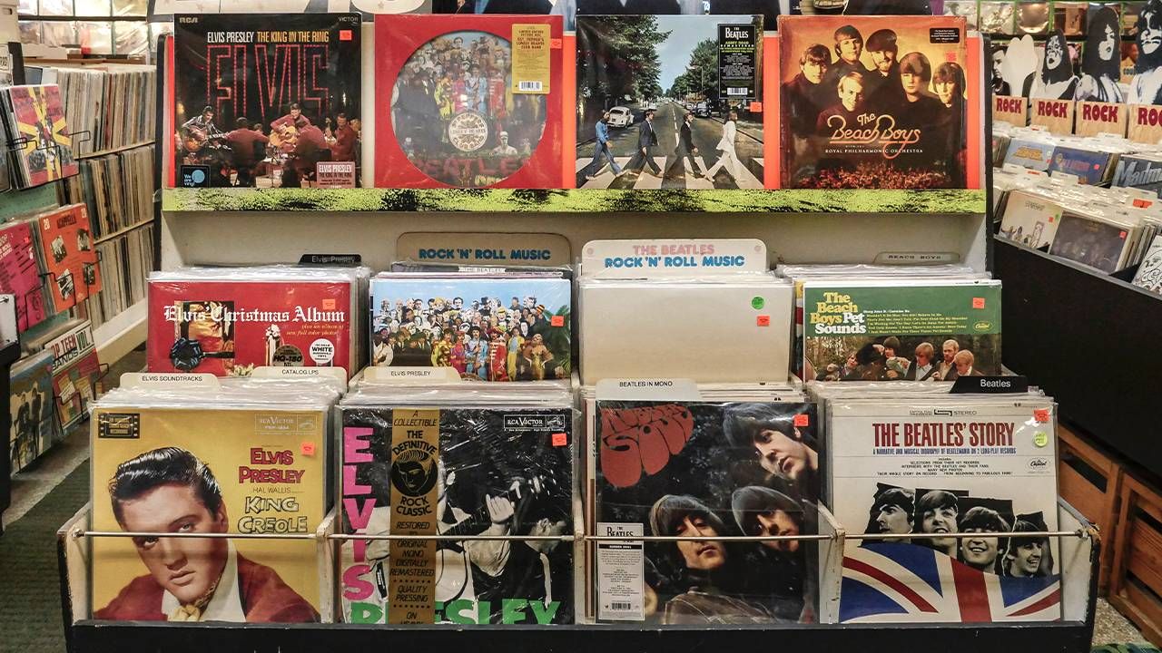 Vinyl records displayed in a store, featuring valuable records from various artists including The Beatles, Elvis Presley, and other classic rock and roll musicians.