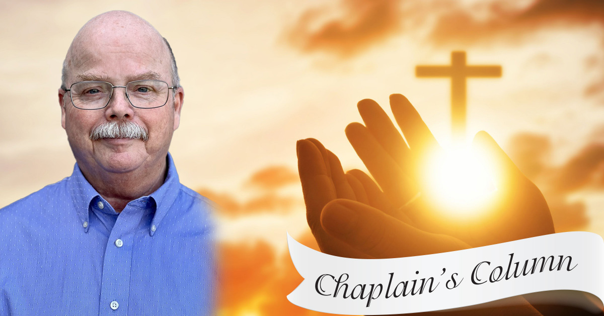 A person in a blue shirt stands next to an image of hands raised towards a shining cross in the sky, celebrating God's Love. Below, a banner reads "Chaplain's Column.