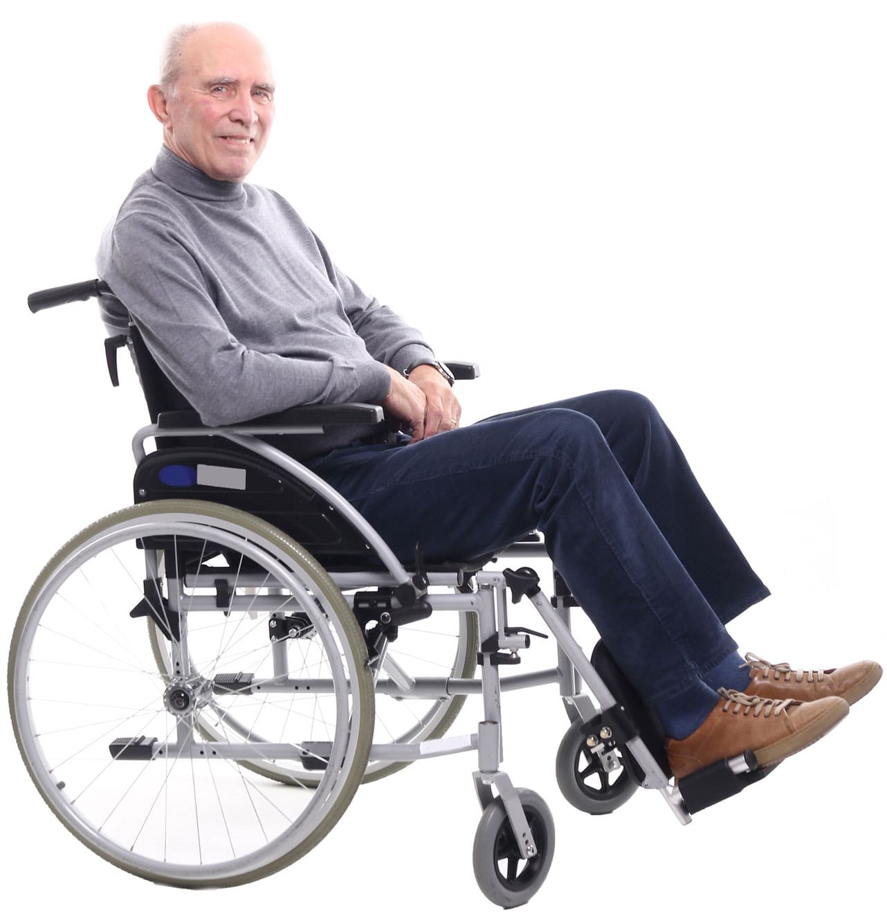 An elderly man in a gray sweater and blue pants sits in a wheelchair, looking at the camera, illustrating the comforting environment provided by long-term care for seniors.